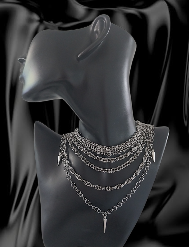 An image of Death in Chains' Elemental necklace: a piece with five chains sitting around the neck of a black plastic bust with steadily increasing orders of length. Each chain is constructed with a different link pattern
